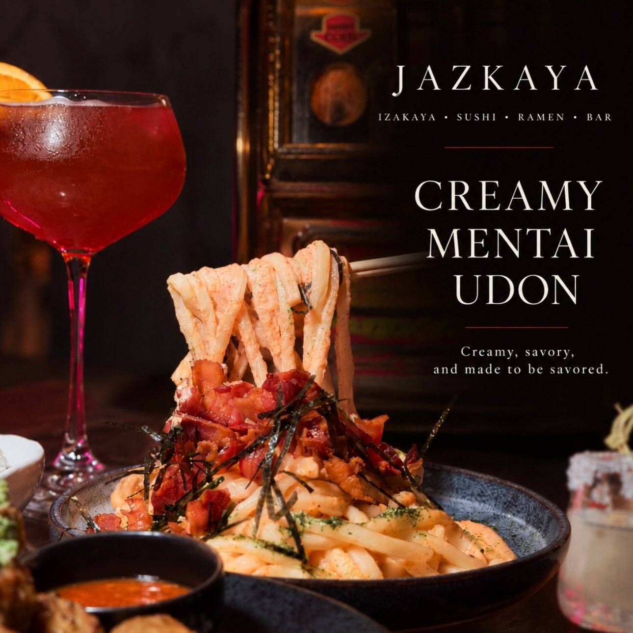 Creamy mentai udon with shrimp and nori in a dark bowl beside a red cocktail, with the dish name lettered on the image.